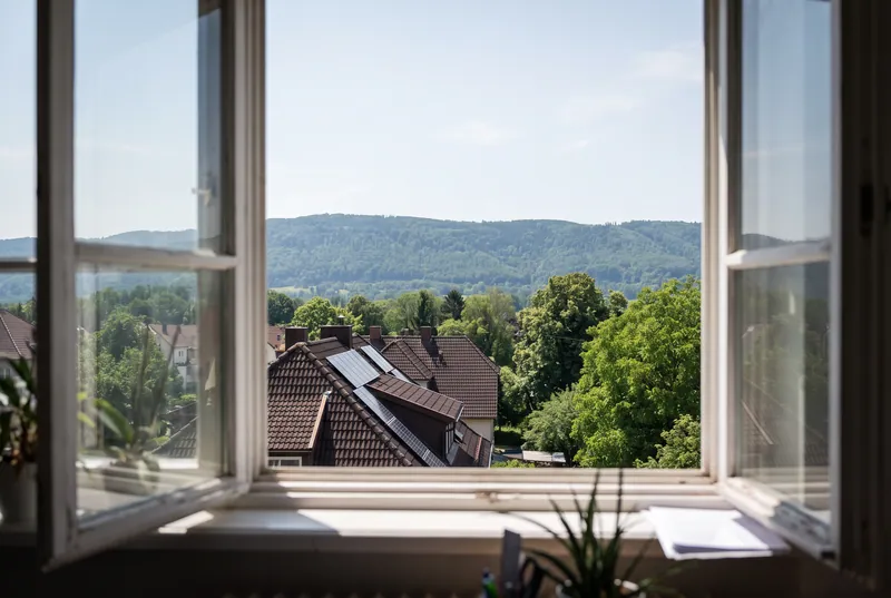 Blick aus dem Bürofenster über die Dächer auf den bewaldeten Jurahang