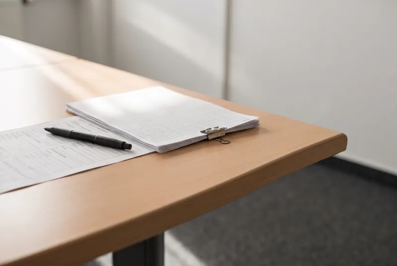 Ein ausgefülltes Formular und ein Stift auf einem Schreibtisch im Büro von Kneubühler Finanz